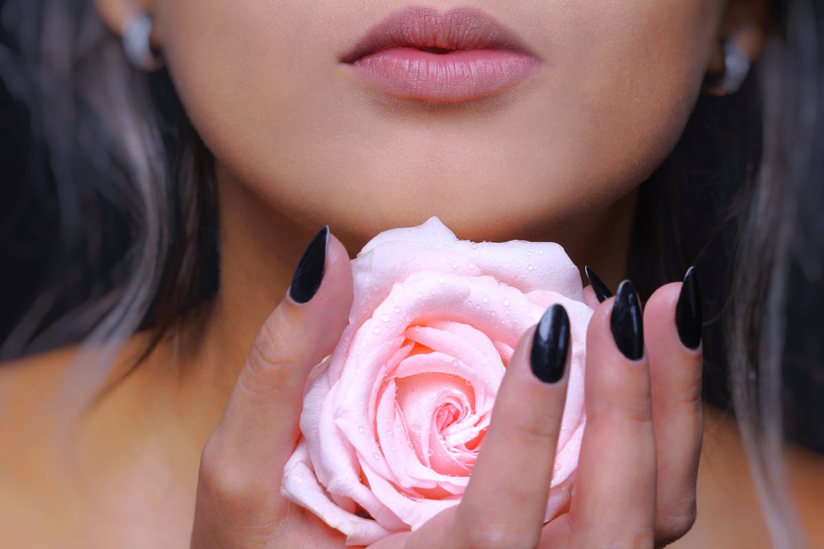 donna con rosa in mano e labbra in primo piano