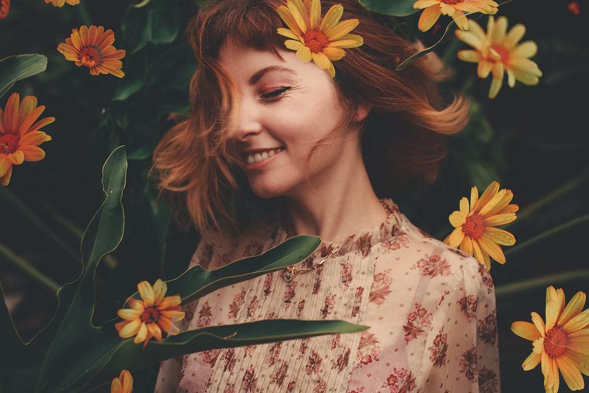 ragazza con capelli rossi e fiori che la attorniano