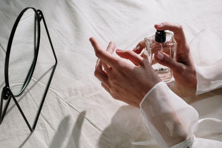 donna che spruzza profumi sui polsi
