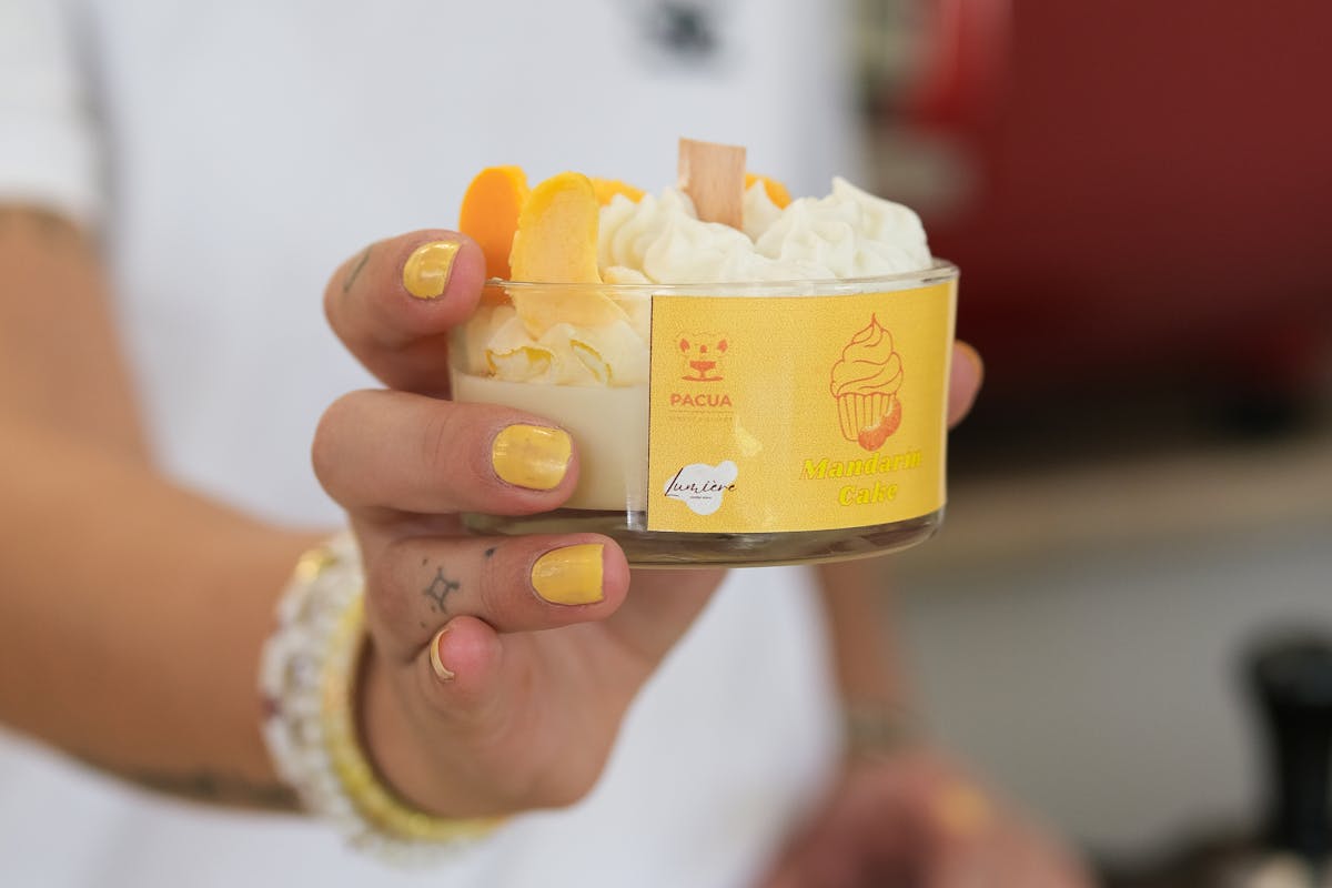 Donna con smalto pesca unghie che porge gelato alla pesca