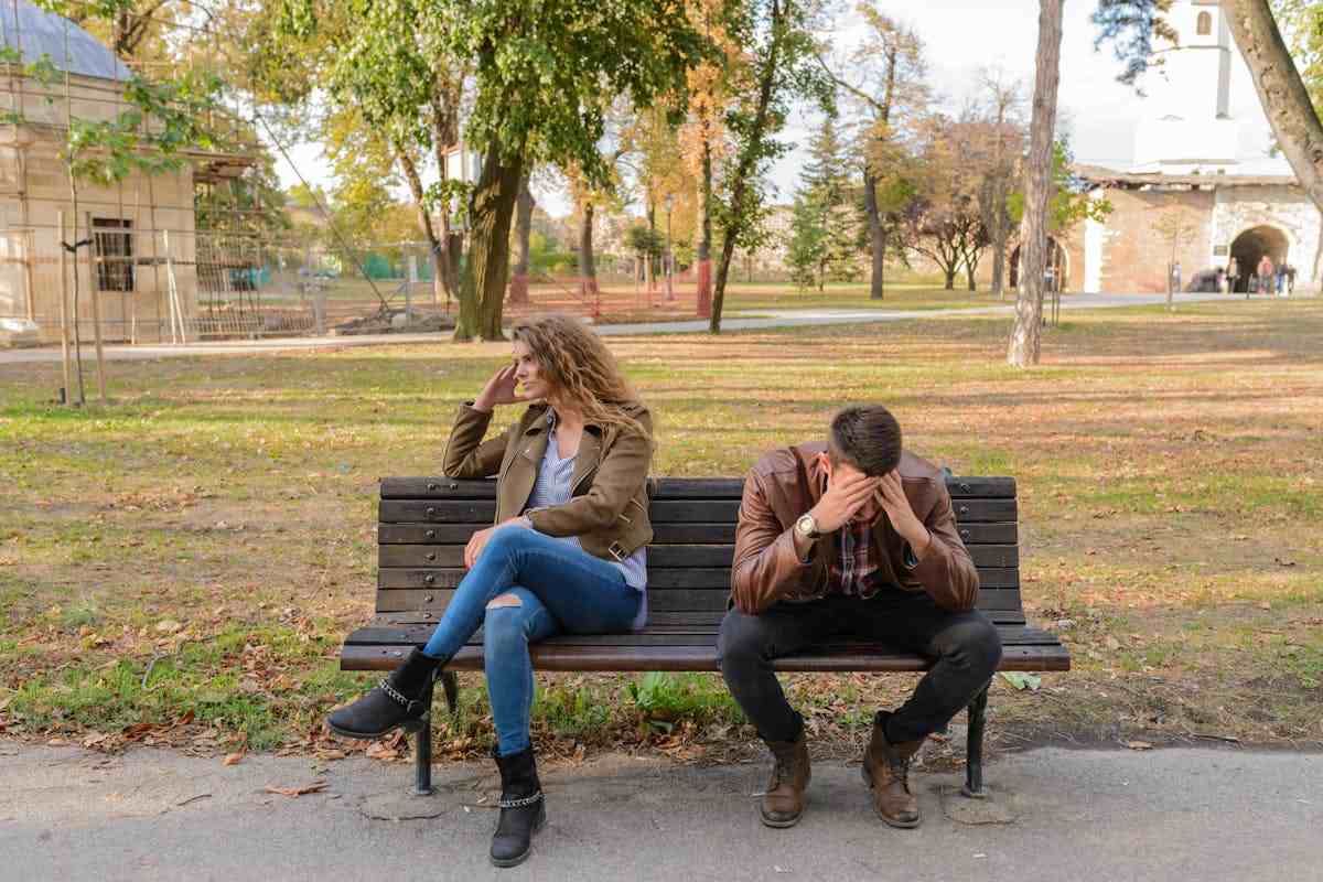 Donna e uomo che discutono seduti su una panchina