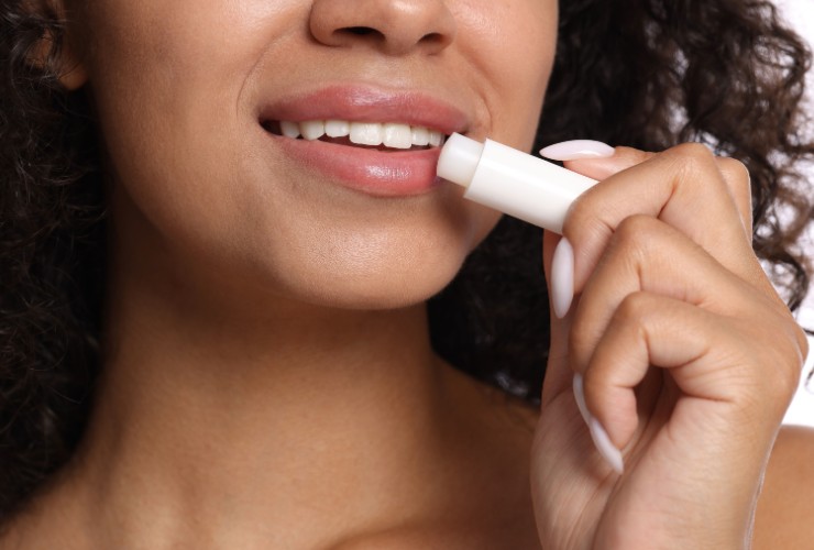 Donna che applica il balsamo labbra