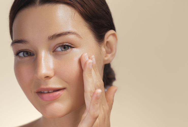Donna che applica crema al viso