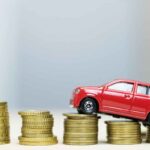 Un modellino di auto su delle colonne di spiccioli