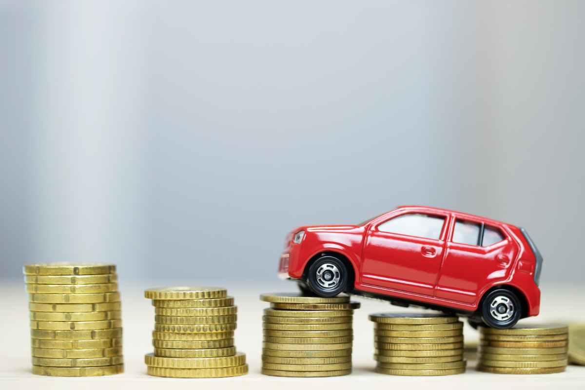 Un modellino di auto su delle colonne di spiccioli