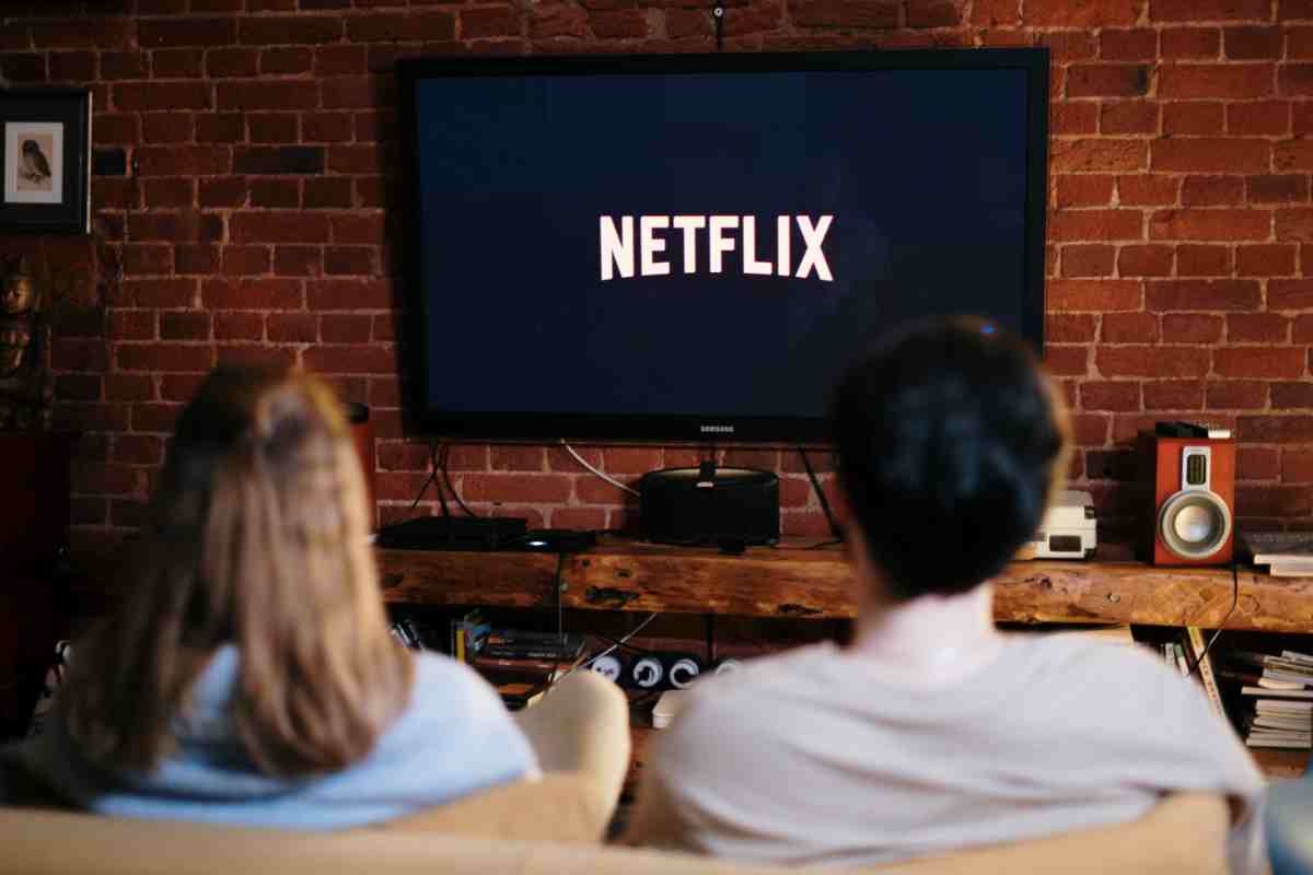 coppia davanti alla tv con la scritta netflix