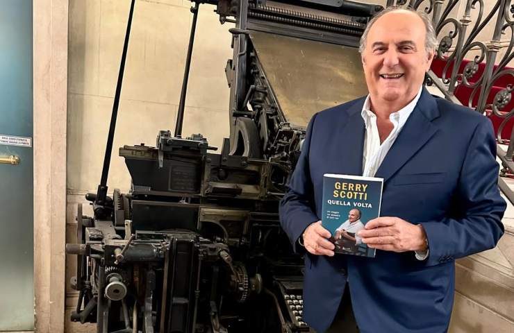 Gerry Scotti sorride col suo libro tra le mani