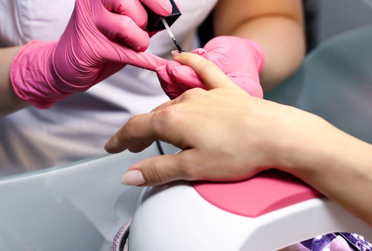 Estetista che applica il gel alle unghie