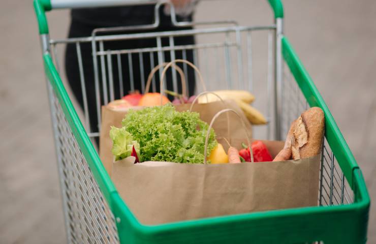 Un carrello della spesa con buste contenenti alimenti