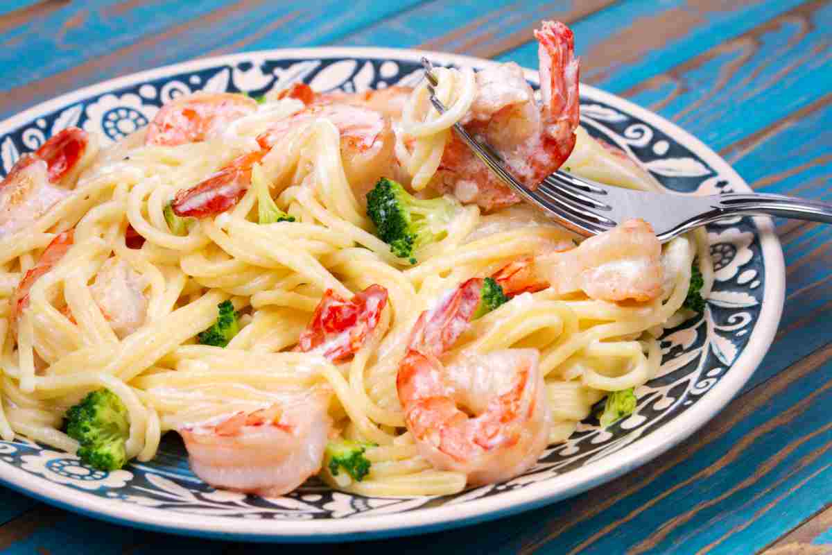 Un piatto di spaghetti cremosi con gamberi e broccoli
