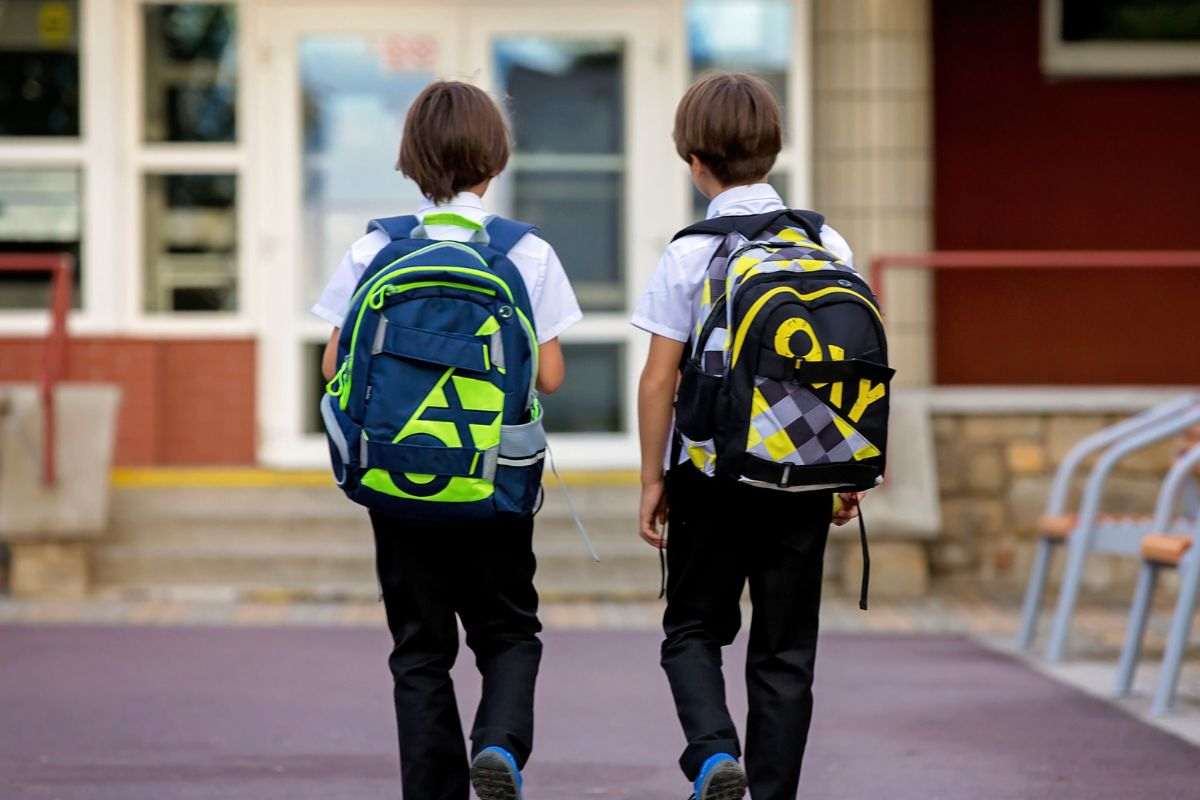 bambini di spalle con zaino in spalla