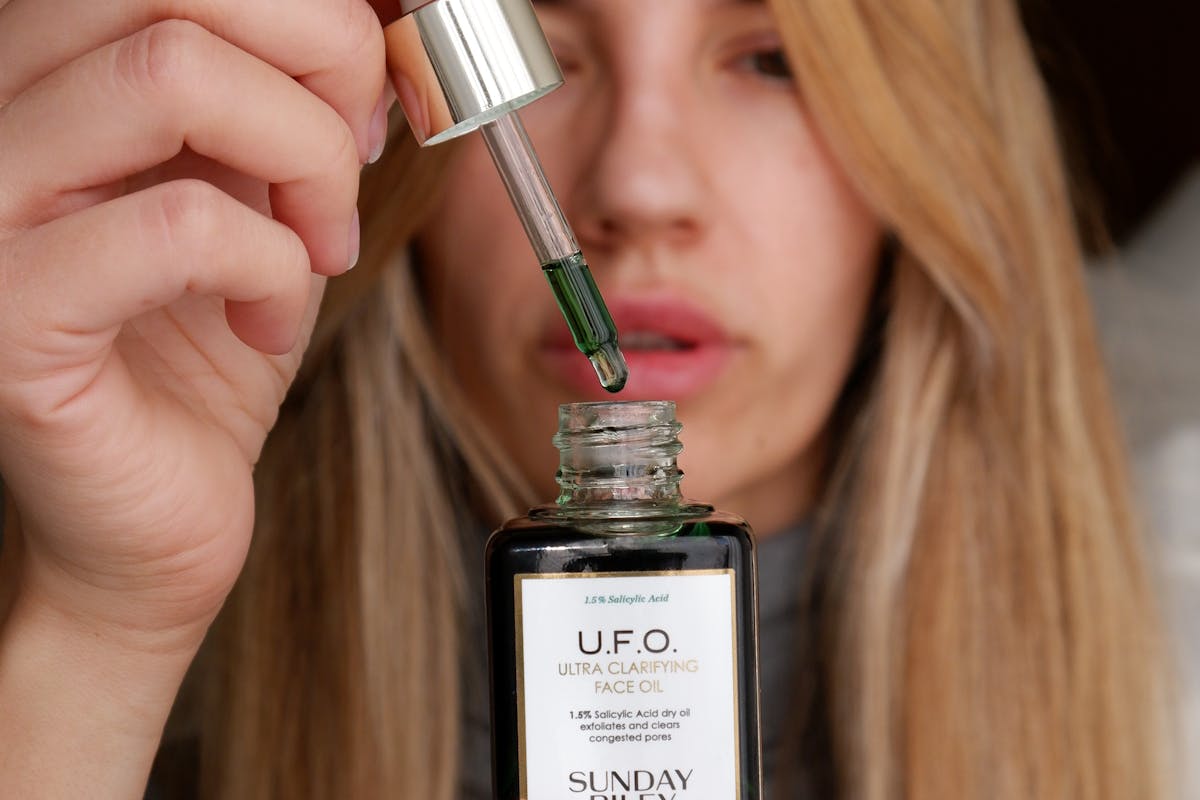 donna con boccetta di olio viso