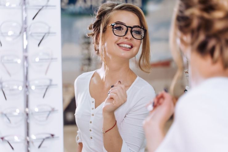 ragazza con occhiali da vista di fronte allo specchio