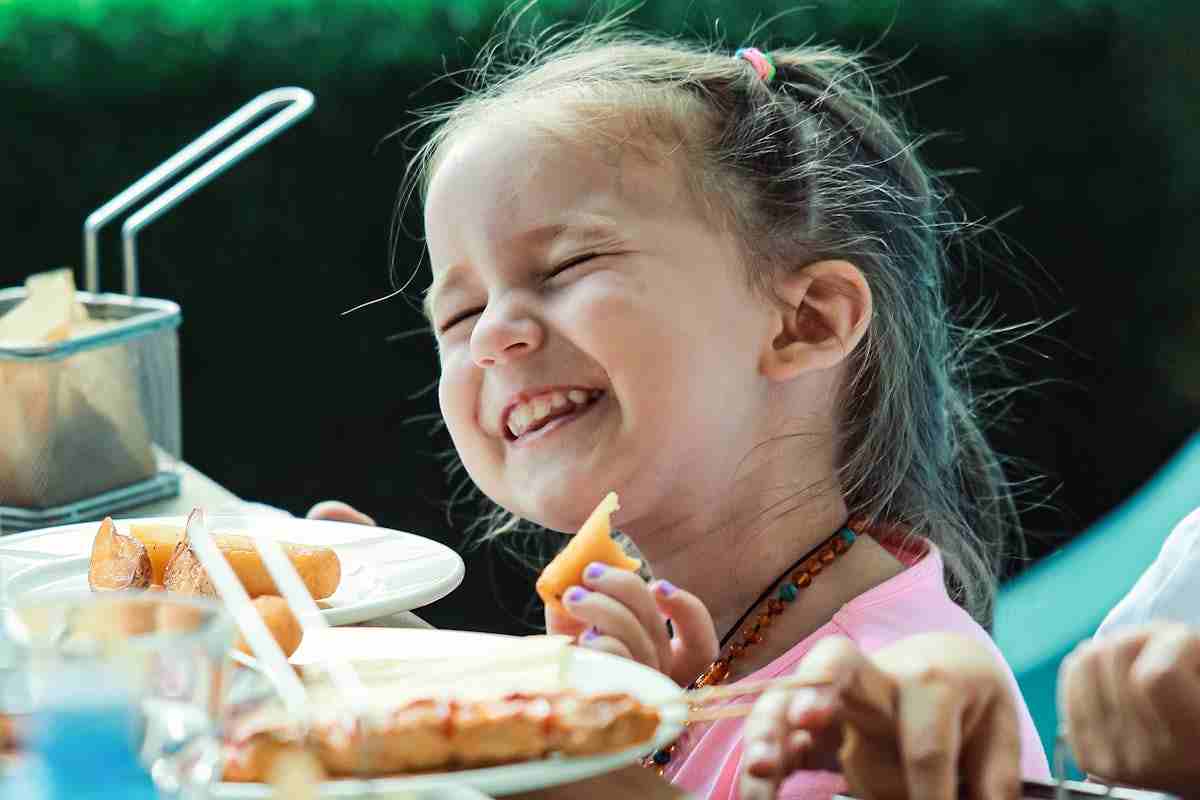 bimba che strizza ochi mentre mangia