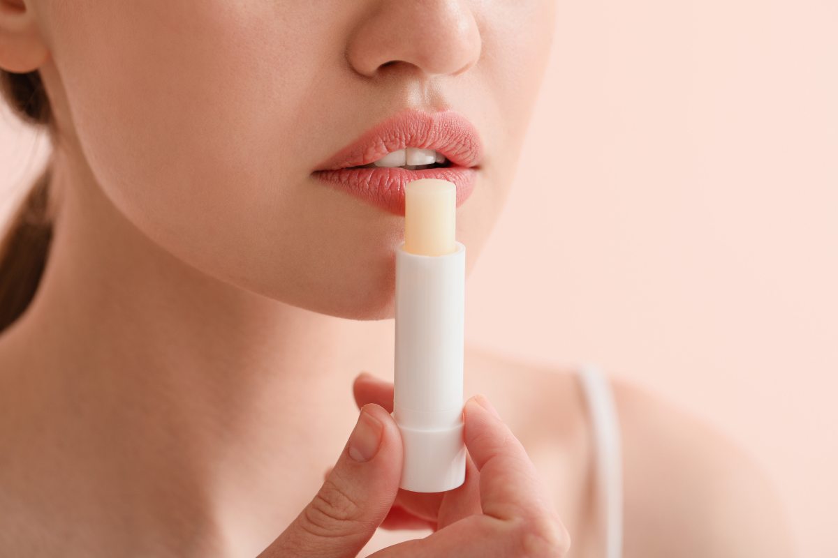 Donna che applica il balsamo labbra