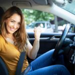 donna in auto che mostra la patente