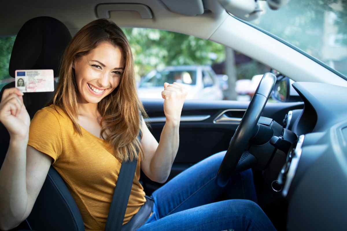 donna in auto che mostra la patente