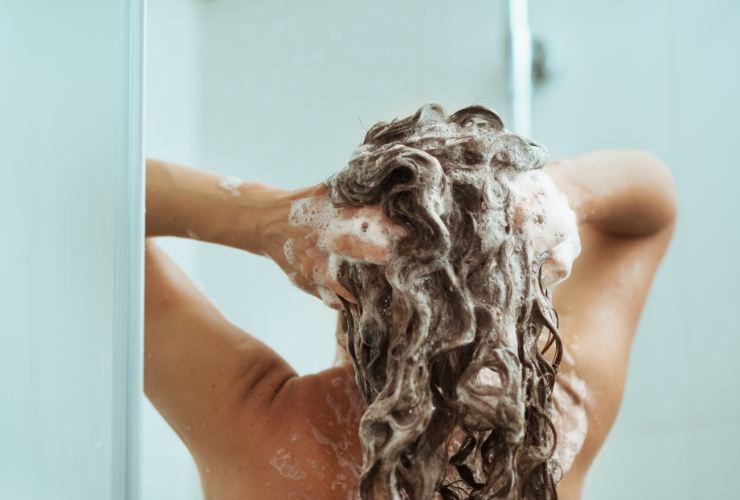 Donna che fa lo shampoo