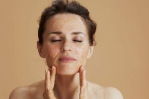 Donna che fa lo scrub viso