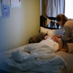 donna che guarda bimbo a letto con febbre