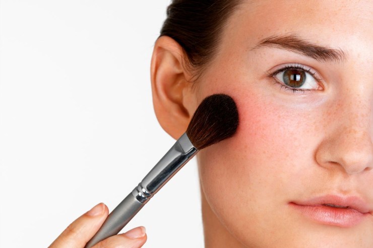 ragazza che applica blush con pennello