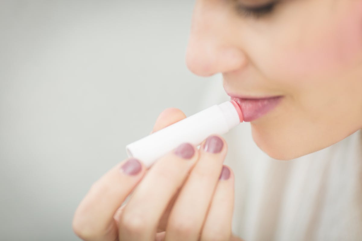 donna che applica balsamo labbra