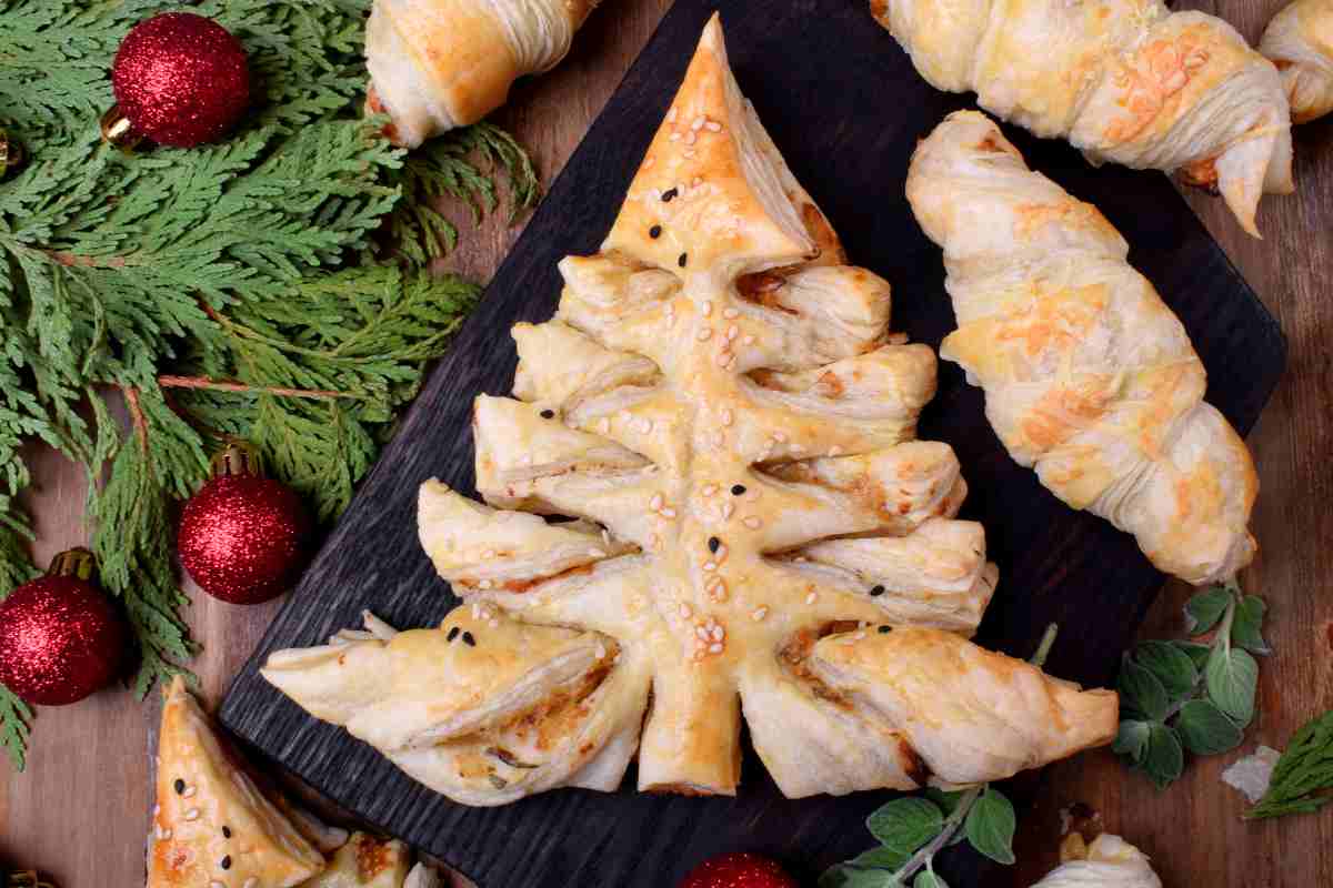 un vassoio con un alberello di pasta sfoglia con prosciutto e formaggio