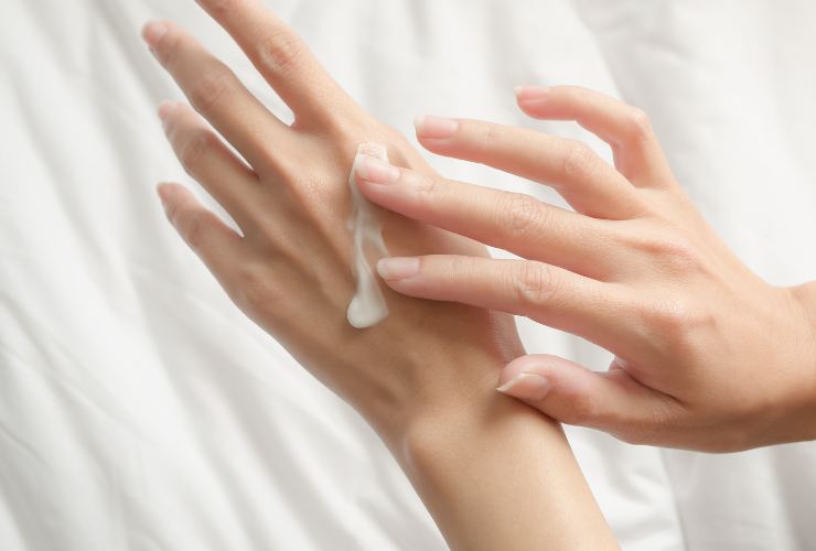 Donna che applica la crema alle mani 