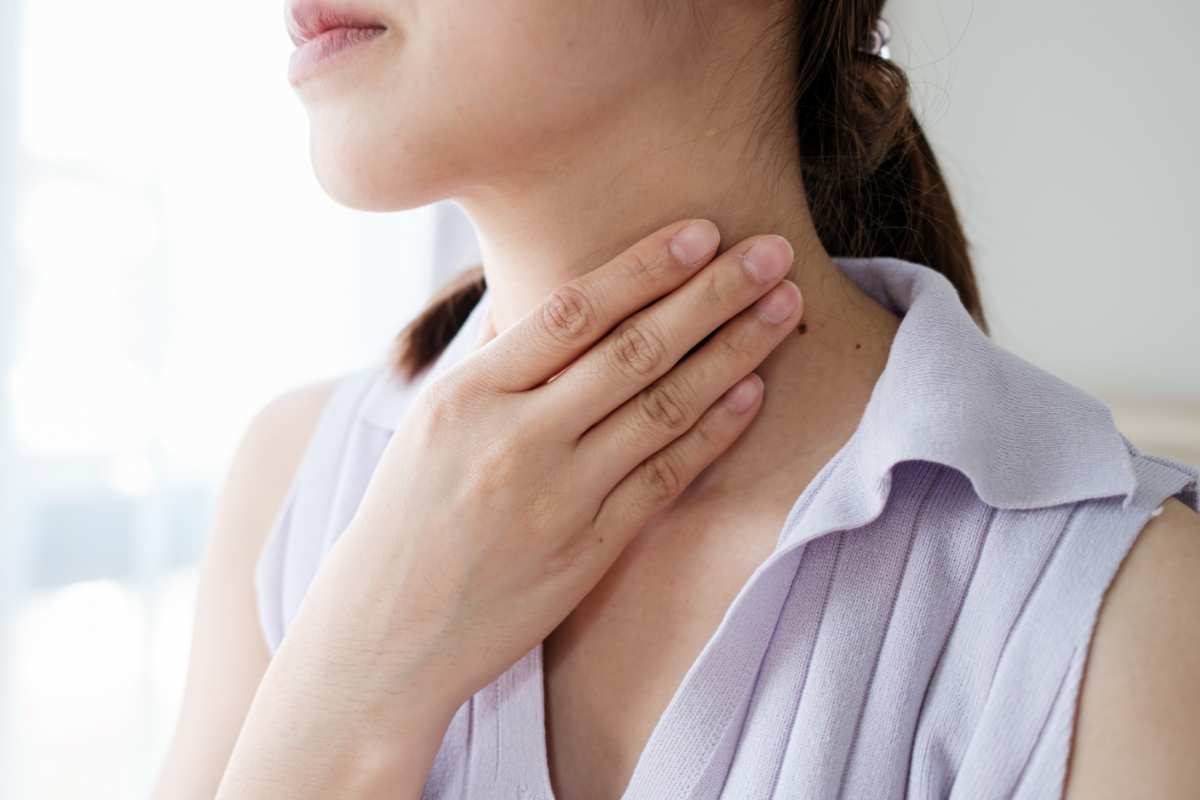 donna si tocca la gola