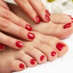 mani su piedi e unghie laccate di rosso