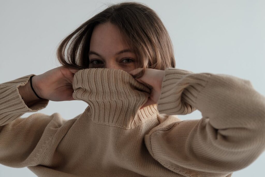 donna che mette pullover beige