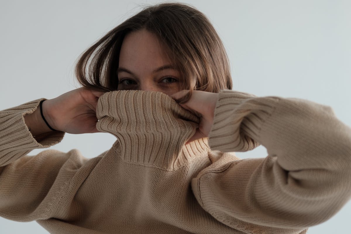 donna che mette pullover beige