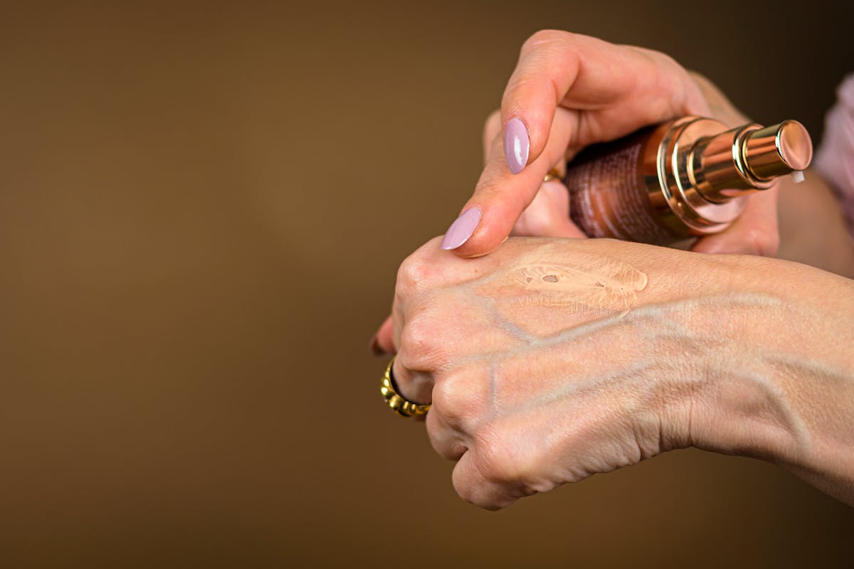 donna che mette fondotinta su mano