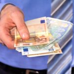 Un uomo che porge banconote in euro