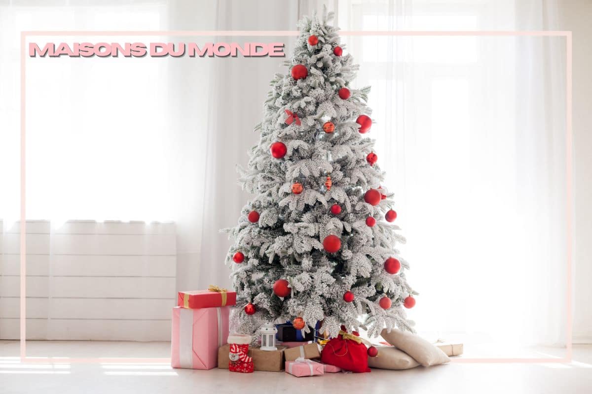 Albero bianco con palline rosse e regali in salotto luminoso