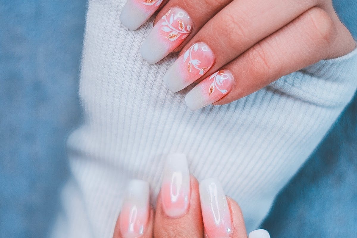 unghie rosa con dettagli disegnati in bianco