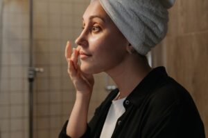 donna che mette crema viso