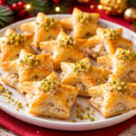 Piatto da portata con Stelline sfoglia ripiene di tonno e philadelphia e sfondo natalizio