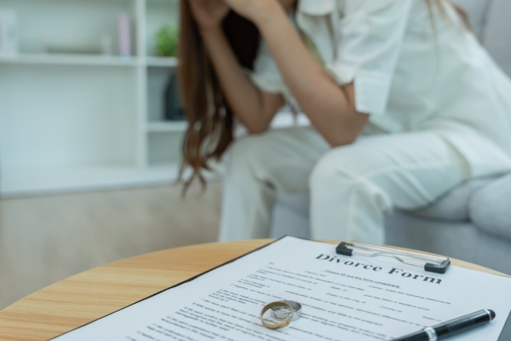 persona sul divano con foglio divorzio
