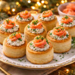 Vol-au-vent con il salmone affumicato su piatto da portata con decorazioni natalizie sullo sfondo