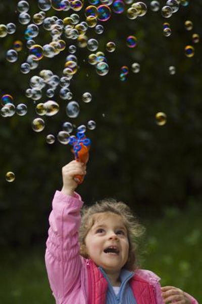 bambina fa le bolle di sapone