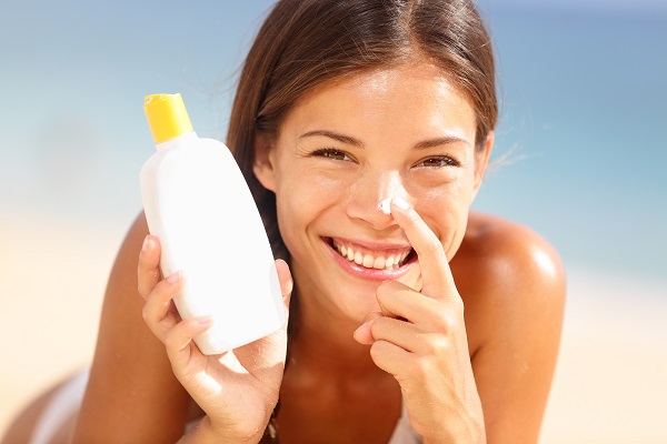 Suntan lotion woman applying