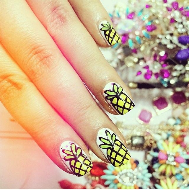 Nail art con ananas su fondo bianco e glitter
