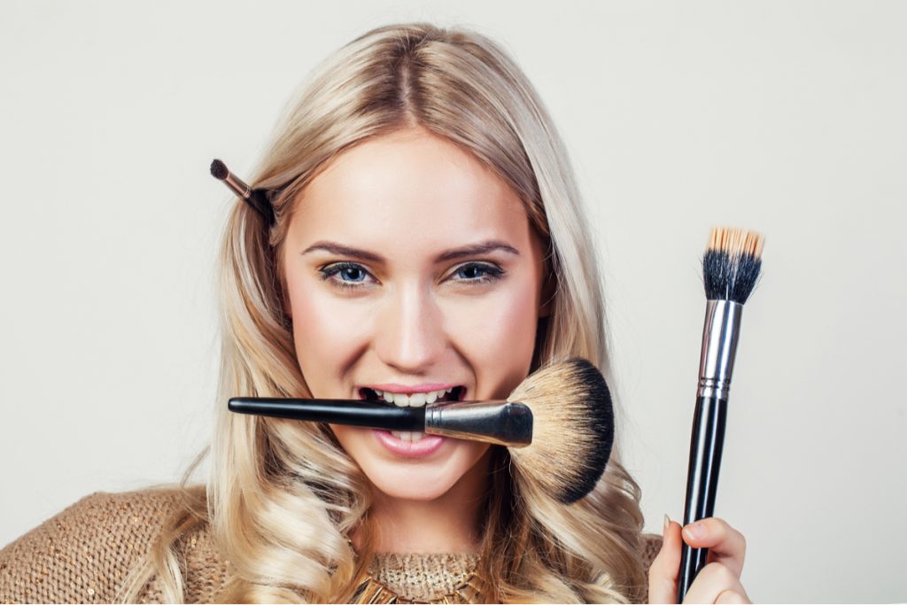 Primo piano di ragazza con pennelli da trucco