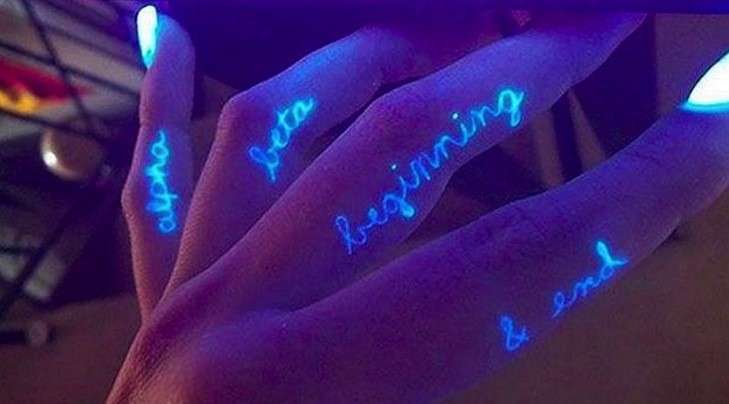 Tatuaggi fosforescenti con scritte sulle dita