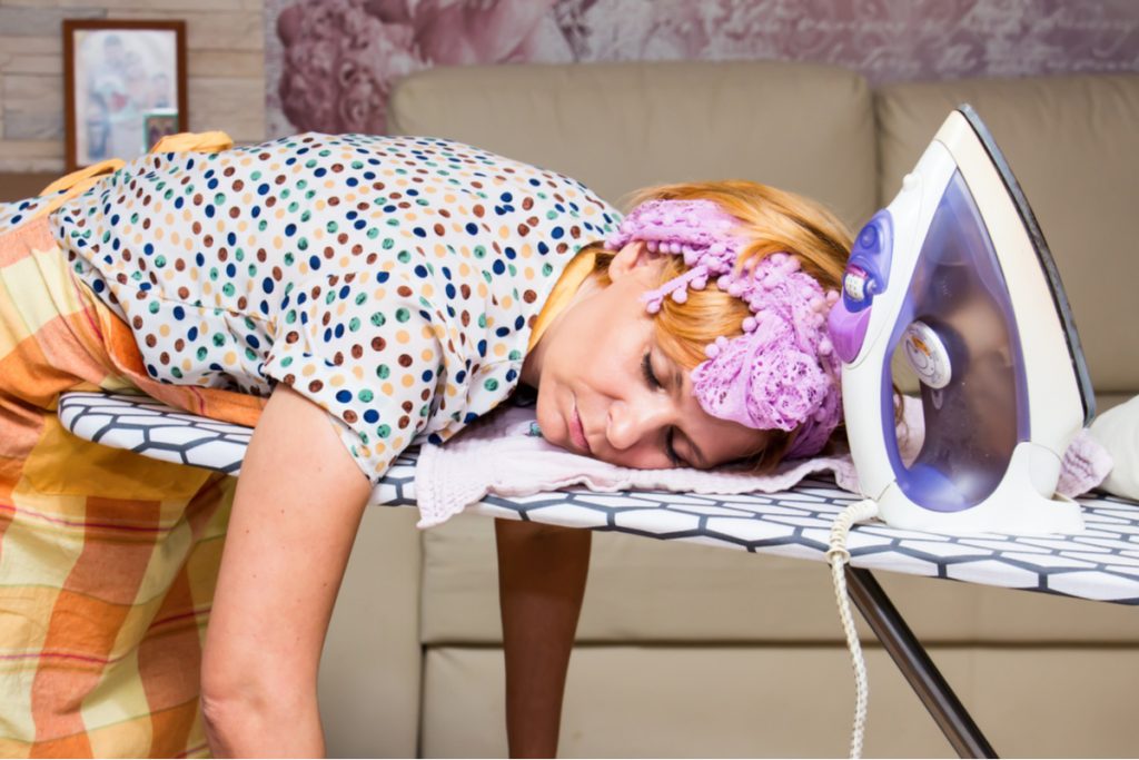 Donna che dorme sull'asse da stiro