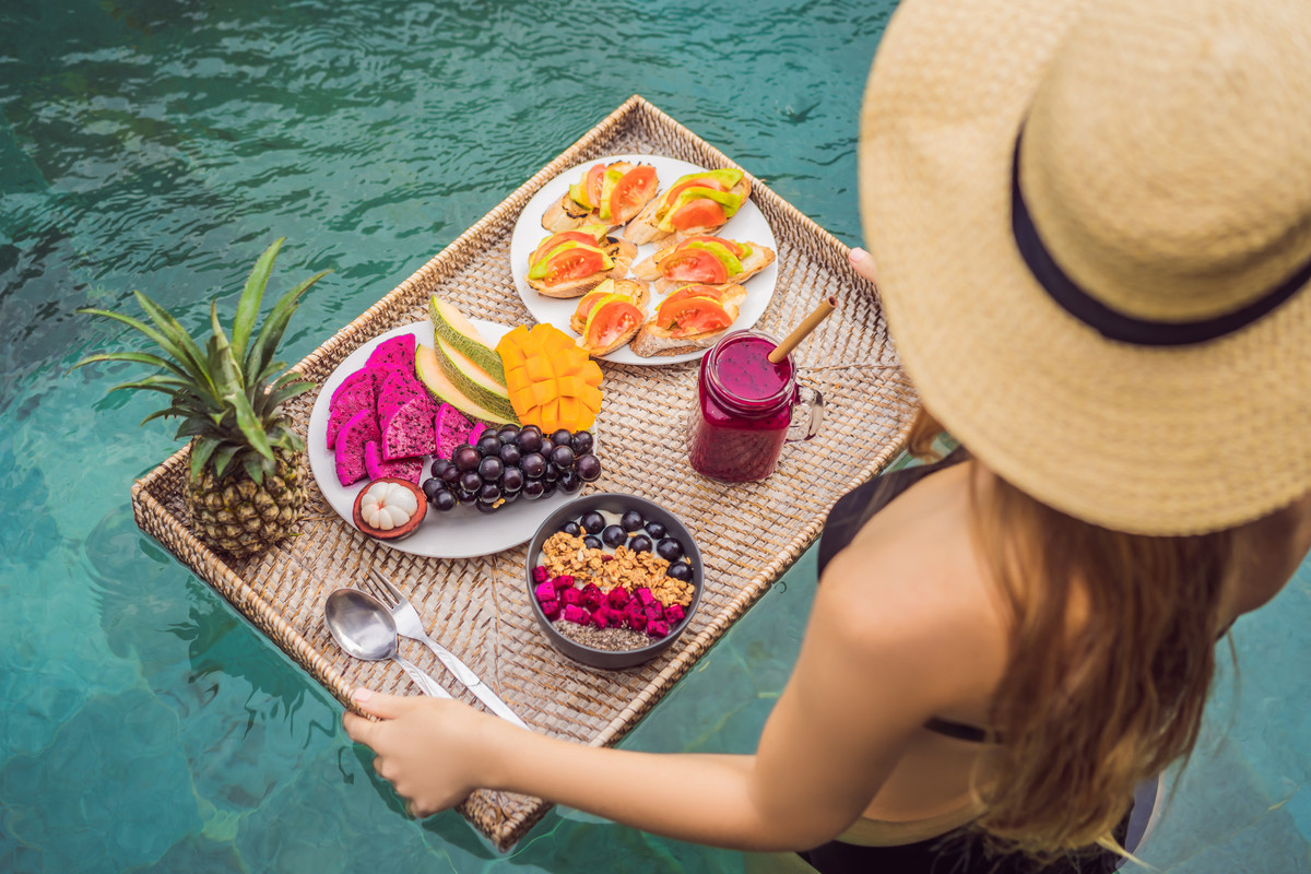 Donna in piscina con un vassoio di frutta