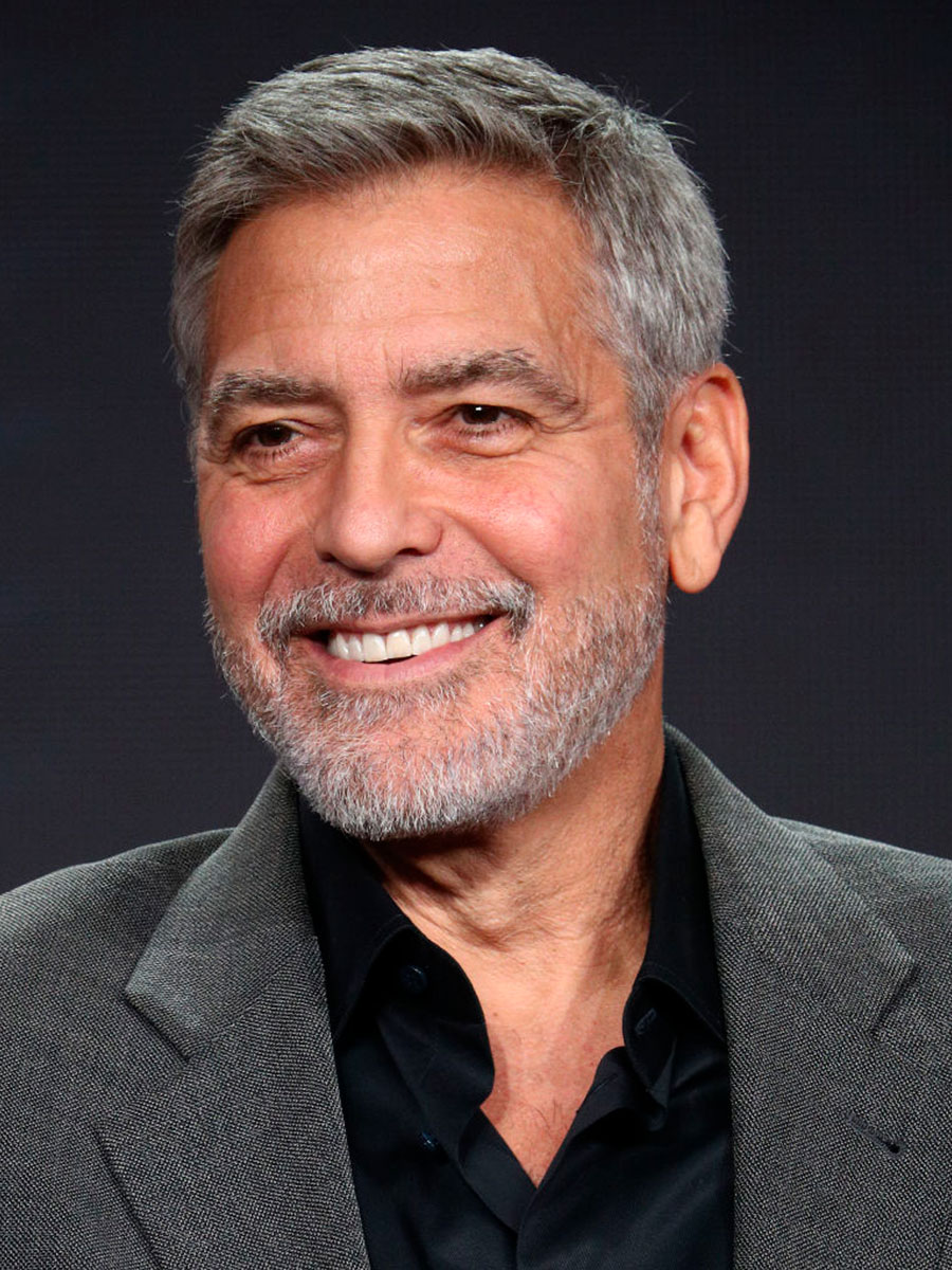 George Clooney con giacca grigia e camicia scura sbottonata