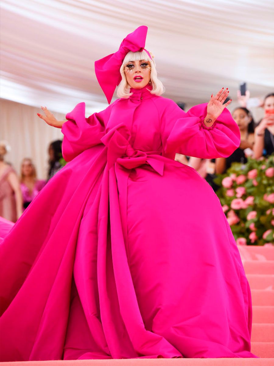 Lady Gaga con un vestito fucsia e fiocco in testa