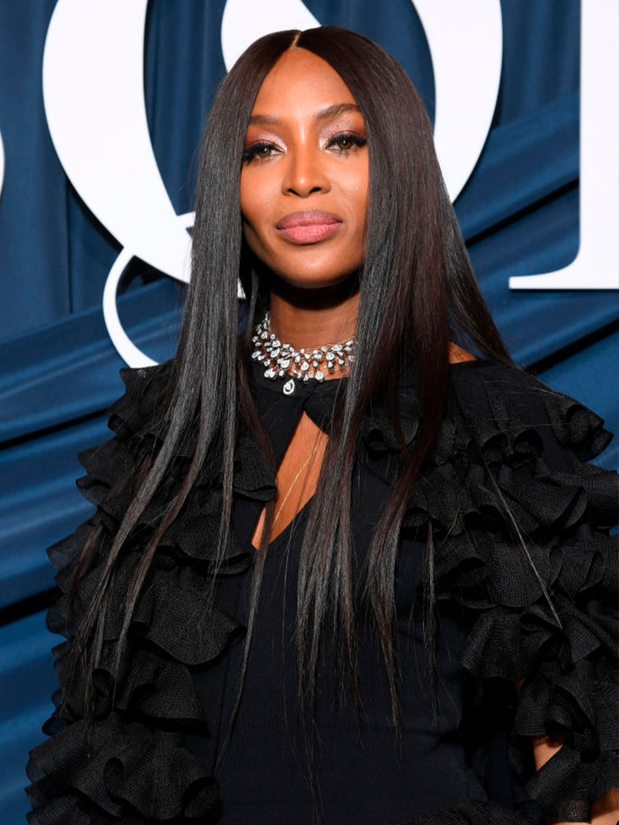 Naomi Campbell indossa un vestito scuro e una collana bianca